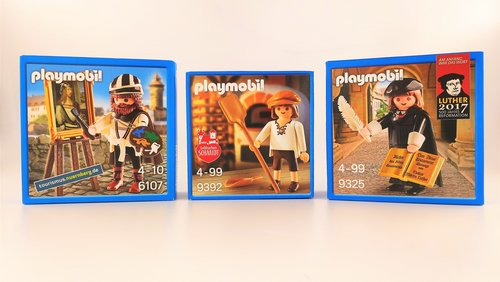 Drei Playmobil-Sonderpackungen nebeneinander: links Albrecht Dürer mit Staffelei, in der Mitte ein Lebkuchenbäcker mit Backschieber und rechts Martin Luther mit Bibel und Feder.