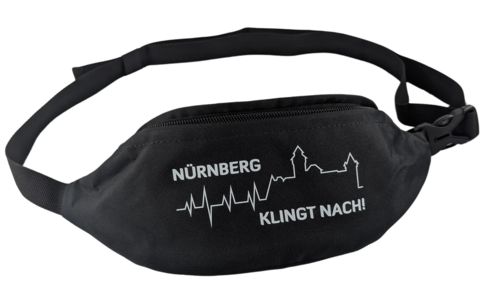 Eine schwarze Bauchtasche mit weißem Aufdruck zeigt die Silhouette der Nürnberger Burg, kombiniert mit einer Herzschlaglinie und dem Schriftzug „NÜRNBERG KLINGT NACH!“.